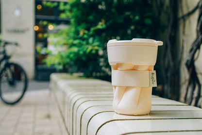 opvouwbare koffiebeker buiten op bankje